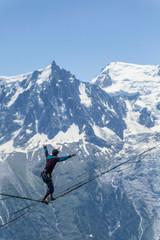 Fototapeta na wymiar A man walking along a sling against the backdrop of the Alps. Chamonix France.