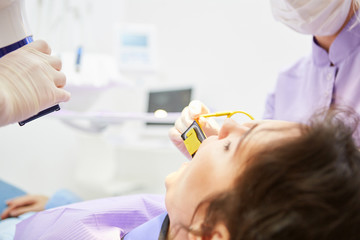 Zahnarzt beim Röntgen von Zahn einer Patientin