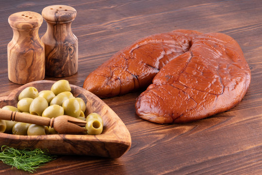 raw smoked cod caviar with olives on wooden background