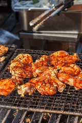 Street food. Fry the chicken in a marinade with spices on the grill. Selective focus