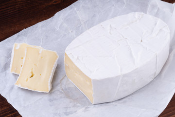 Sliced smelly camembert cheese on a wooden rustic table