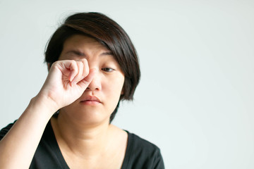 Woman in sleepy face is rubbing her eye.