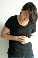 Woman stand bend and press belly with painful from stomach ache.