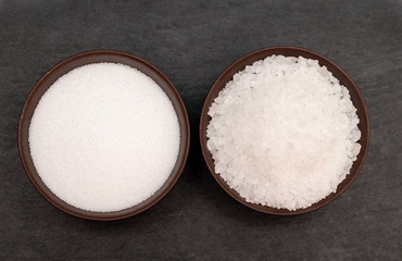 Coarse and fine salt white sea salt on black background.