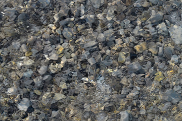 Top view of blue, green and turquoise colors of water, surface of sea on rocks and bottom....