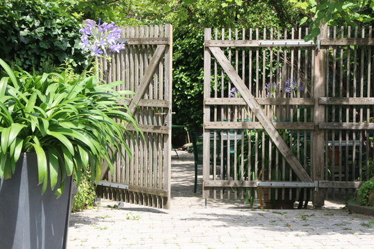 Gartenzaun aus Holz, Gartentor &ouml;ffnet sich zu einem Garten