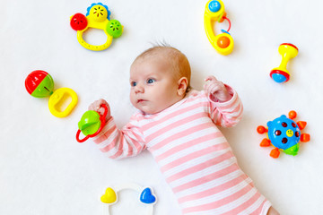 Cute baby girl playing with colorful rattle toys