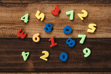 multi colored toy numbers on a wooden table. Concept of mathematics, education and child learning