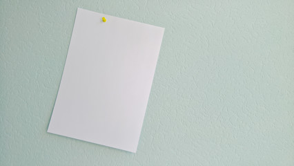 White blank sheet of paper pinned to a wall.