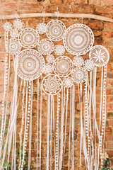 white crochet dreamcatcher on brick wall