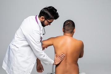 Young indian male doctor and patient suffering from back pain during medical exam.