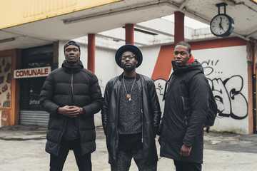 portrait of three young african men posing outdoor in the street – relaxing, youth, thoughtless