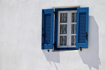 Typical blue Greek window shutters and window with white wall, Naxos, Greek Islands