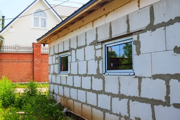 facade of cottage under construction with new inserted windows.