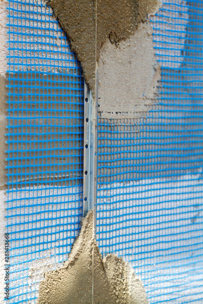 Poster surface of wall with applied construction grid and guides for plaster application