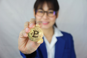 An business asian girl is holding bitcoin on white background.