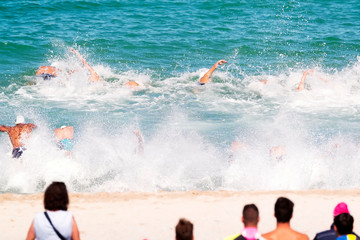 triathetes in swimming race in triathlon  competition in beach