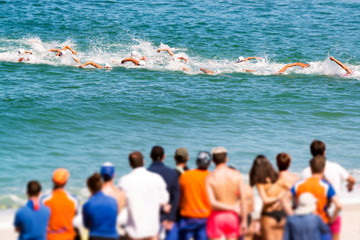 triathetes in swimming race in triathlon  competition in beach