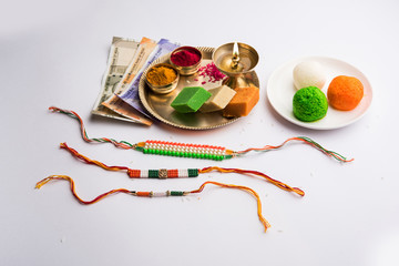 Tricolour Rakhi and Sweets for Independence Day / Raksha Bandhan which is on the Same Day in 2019, puja thali decorated with diya, haldi/kumkum and indian currency as gift