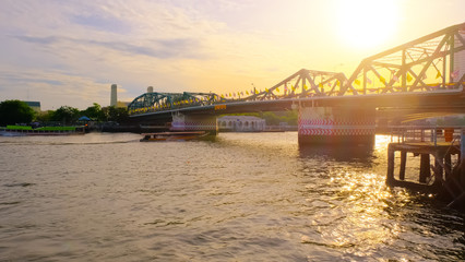Fototapeta premium View of Phra Phuttha Yodfa Bridge At the Chao Phraya River, Memorial Bridge in transportation concept at Chao Phraya River. Bangkok at sunset