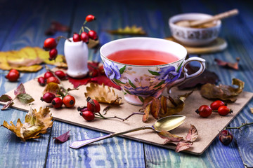 Cup of hot red tea with honey and dog-roses.