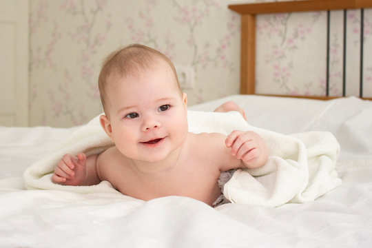 Baby girl boy 5 months smiling, baby in bedroom, European Caucasian, soft focus