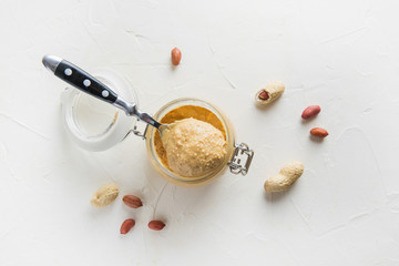 Peanut paste in glass gar. Healthy nutrition concept.
