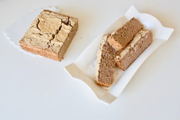Tasty bread in the white plate on the white table.