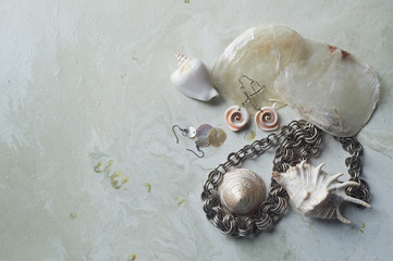 Sea collection on grey marble background.Seashell and mother-of-pearl earrings. Summer...