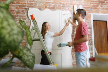Young couple doing apartment repair together themselves. Married man and woman doing home makeover...