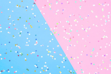 Confetti scattered on blue and pink paper