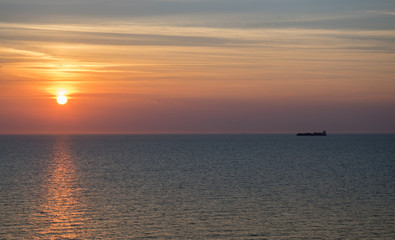 Naklejka na ściany i meble Sunset in the sea on a warm summer evening, seascape.