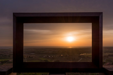 Beautiful sunset over the sea framed by a large black frame