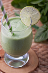 Spinach smoothie with lime in a glass cup