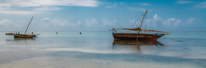Zanzibar in Tanzania, beautiful beach with white sand, typical fishing boat