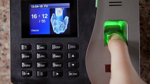 A girl placing her thumb on the biometric scanner machine for office attendance. 