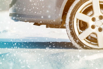 Close-up of car wheels rubber tires in deep winter snow. Transportation and safety concept.