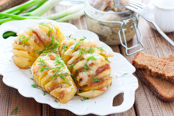 Homemade oven roasted baked potetoes with cheese, bacon, spices and herbs , selective focus