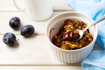 Plum granola in the white baking ceramic form
