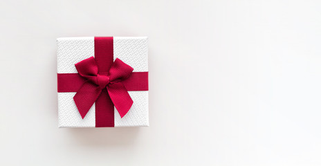 White gift box with red ribbon isolated on white background. Top view.