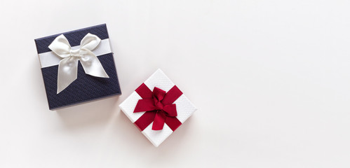 White gift box with red ribbon and blue gift box with white ribbon isolated on white background. Top view.