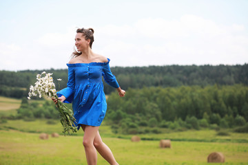 Obraz premium Young cute girl run in a field at sunset