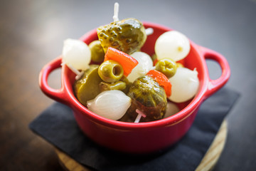 spanish banderillas, skewers with pickling olives, garlic, pickles, onion and red pepper