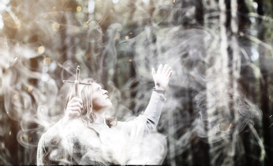 Fairy magician. A sorcerer with a glass sphere, a magical spell and a ritual. Elder with a staff and a cross in the forest. Black and white magic. A spell in an old book.