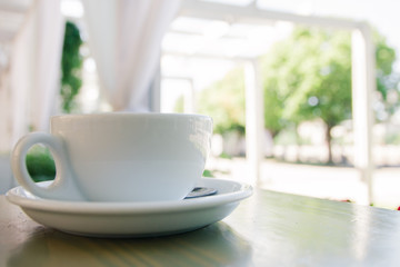 Cup of fresh cappuccino coffee on the table in summer cafe