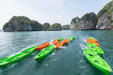 Fototapeta na wymiar Green and orange plastic kayaks in Halong bay, Vietnam