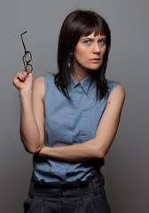 Picture of Young woman wearing modern eyeglasses anf thinking isolated on grey background