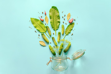 Pickled cucumbers. Ingredients for marinated gherkins and glass jar on blue background. Concept culinary recipe preservation of vegetables in harvest season. Creative flat lay Top view Copy space