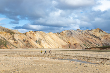 Tourista walk in Landmannalaugar, beautiful scenic nature landscape. Various volcanic minerals, creek and lava formations. Colorful mountains in Iceland