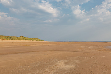 Fototapeta na wymiar Looking along the vast sandy beach in Formby, Merseyside, on a sunny summers day